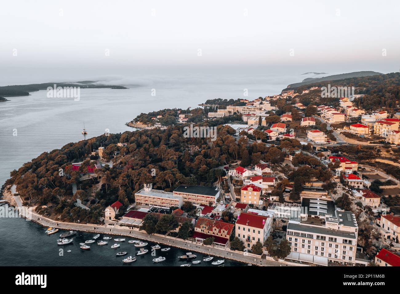 Luftaufnahmen halten die Schönheit der Küste von Hvar bei Sonnenaufgang an einem Sommermorgen fest. Das kristallklare Wasser und die zerklüfteten Klippen werden von der beleuchtet Stockfoto