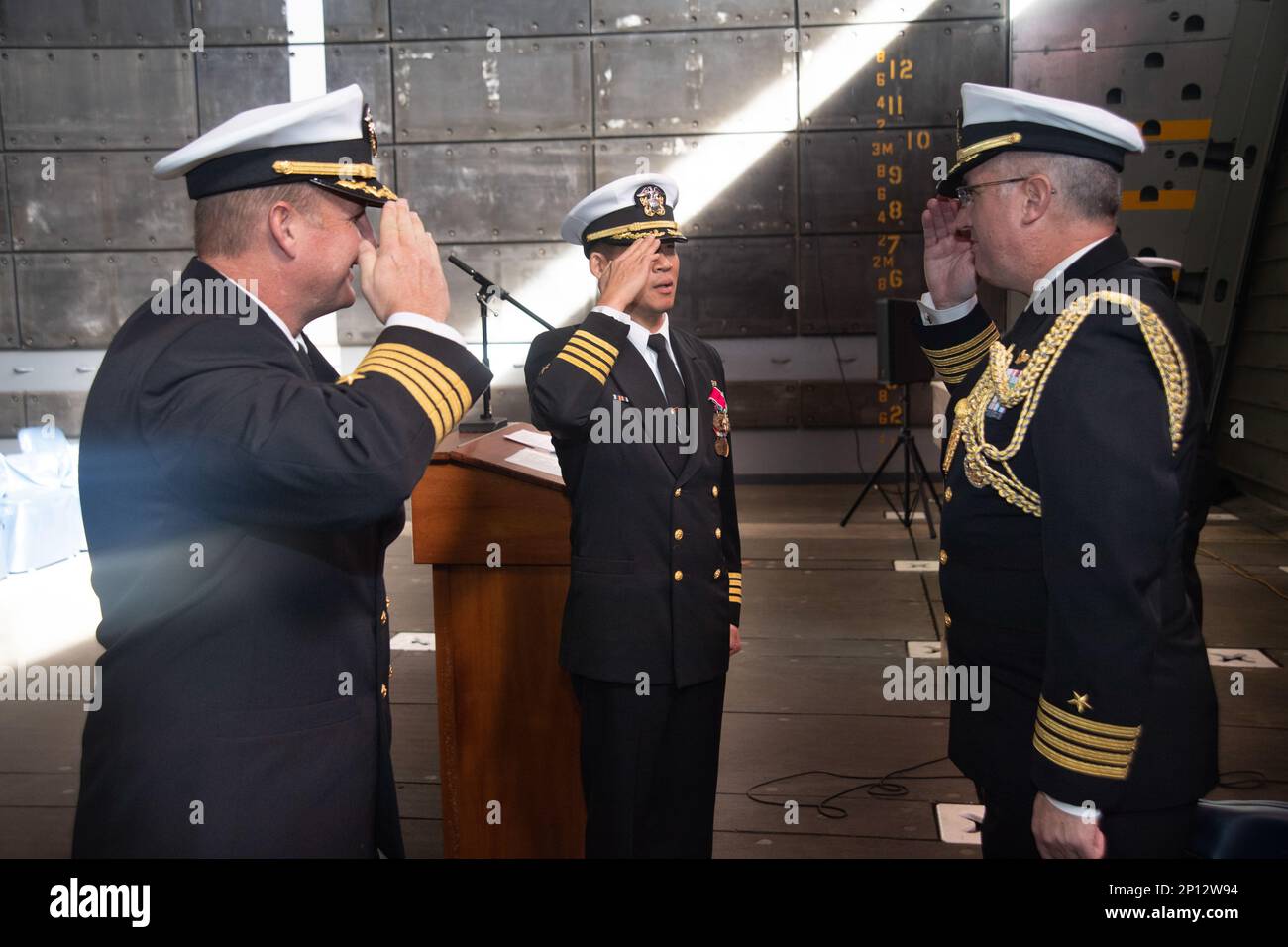 MARINESTÜTZPUNKT SAN DIEGO (12. Januar 2023) Kapitän Brian Quin, rechts, Stabschef, Expeditionary Strike Group 3, grüßt Kapitän Ryan Rogers, links, als er Kapitän Hank Kim als kommodore des Amphibiengeschwaders (PHIBRON) 3 während einer Zeremonie zum Kommandowechsel an Bord des Amphibienschiffs USS San Diego ablöst (LPD 22). Rogers hat Kim während der Zeremonie als kommodore von PHIBRON 3 abgelöst. Stockfoto