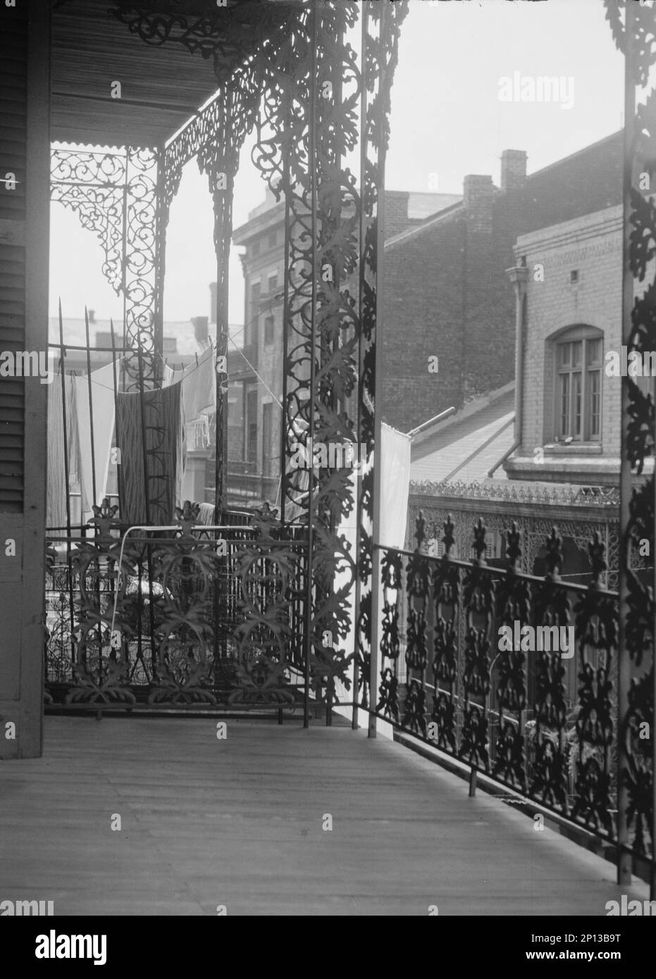 Balkone im oberen Stockwerk mit schmiedeeisernen Elementen auf der St. Peter Street, New Orleans, zwischen 1920 und 1926. Stockfoto
