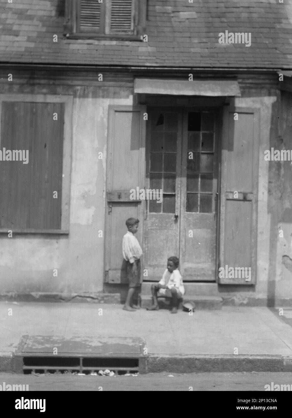 Zwei Kinder vor einer Tür mit Fensterläden im French Quarter, New Orleans, zwischen 1920 und 1926 Uhr. Stockfoto