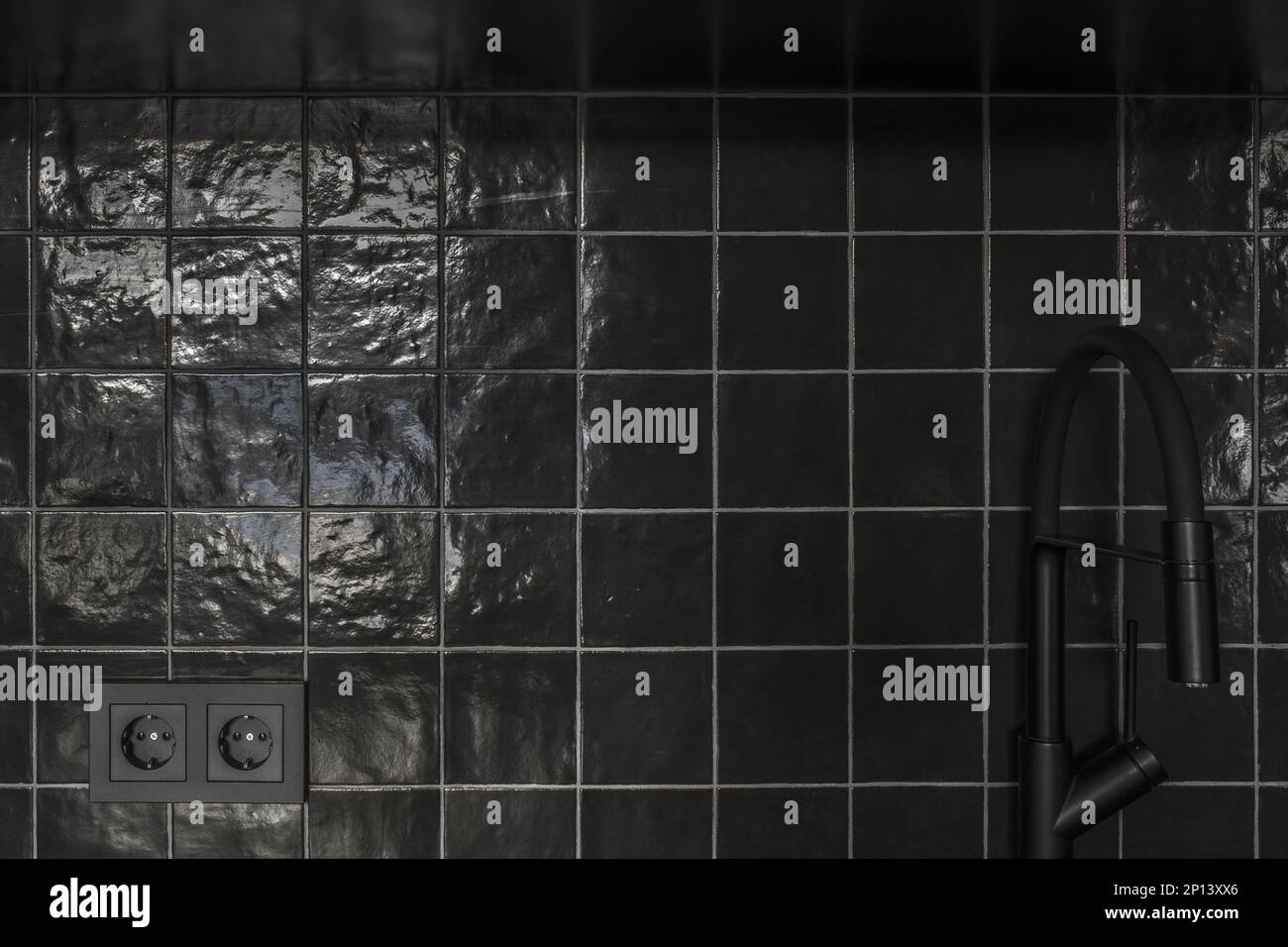 Kleine Kücheneinrichtung in grauen und schwarzen Farben, Betonwände, schwarze Fliesen. Zeitgenössische Innenraumgestaltung Stockfoto