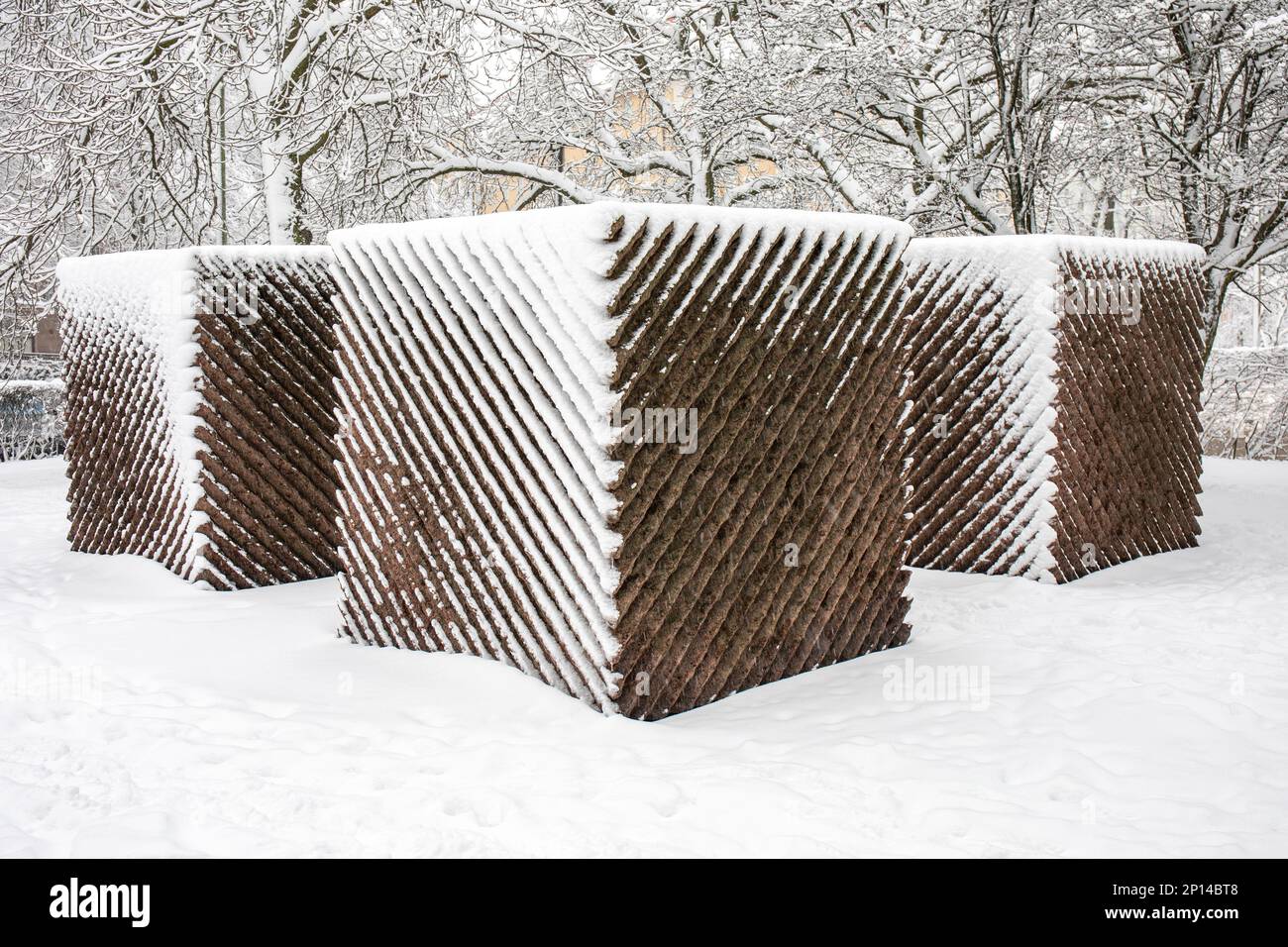 Relander-muistomerkki oder Relande Memorial, ein diagonal genutetes abstraktes Denkmal aus großen Granitwürfeln, das in Helsinki, Finnland, mit Schnee bedeckt ist Stockfoto