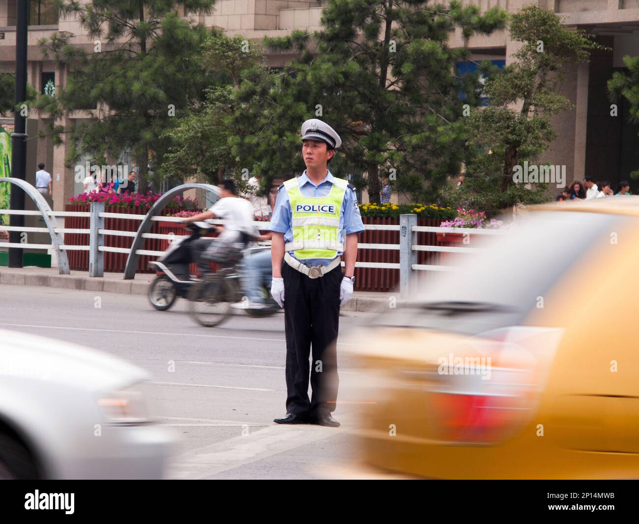 Polizist des Verkehrspolizisten an einer verkehrsreichen Kreuzung in der chinesischen Stadt Xi'an. VR CHINA. China. Führen und Anweisen von vorbeifahrenden Fahrzeugen. (125) Stockfoto