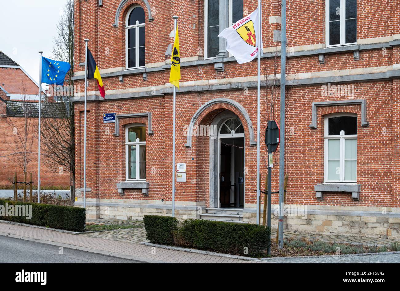 Merchtem, Flämische Region Brabant, Belgien, 25 2023. Februar - Fassade mit Flaggen des Dorfes und municipâlity-Halle Stockfoto