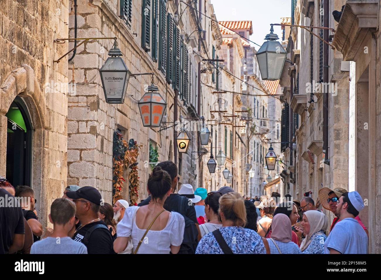 Touristen in der belebten engen Gasse Ulica od Puča / Straße der Brunnen in der Altstadt, historisches Stadtzentrum von Dubrovnik, süddddalmatisches Kroatien Stockfoto