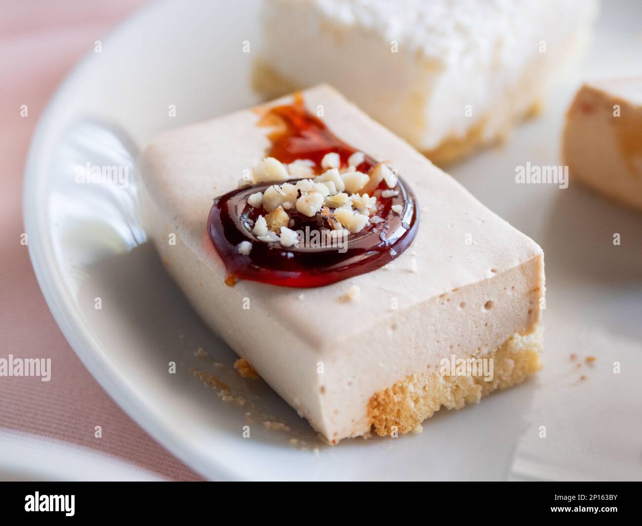Weißer Teller mit verschiedenen Gebäckstücken. Leckere Desserts mit Belag, Kokosnussflocken. Stockfoto