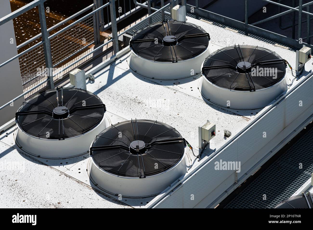 Vier große industrielle Ventilatoren auf dem Dach des Produktionsgebäudes. Draufsicht. Stockfoto