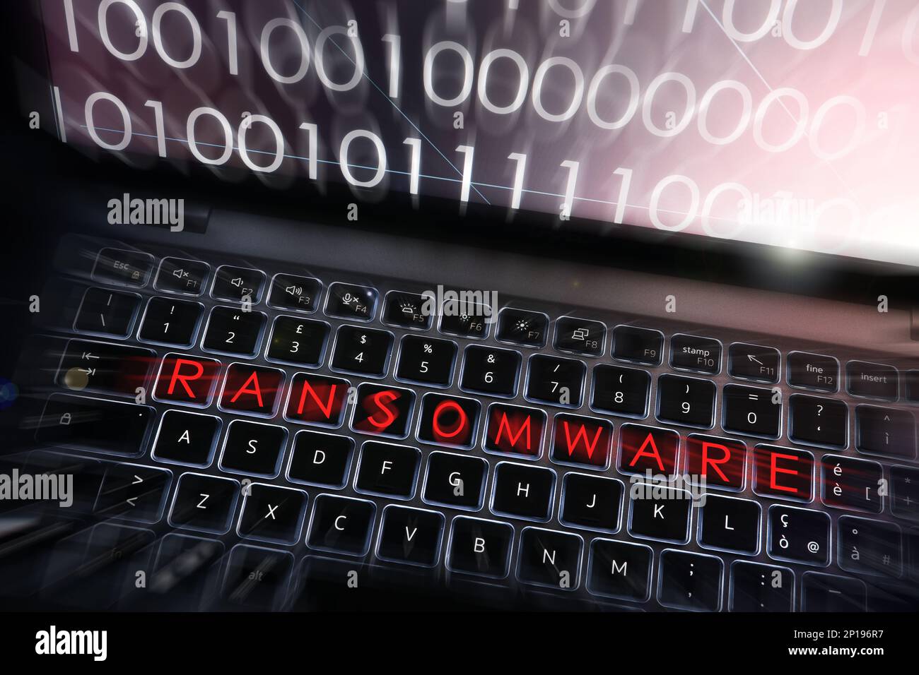Ransomware-Text auf beleuchteter Tastatur eines modernen Laptops mit Sequenzen von 0s und 1s auf dem Bildschirm. Cyber Threat Concept Image. Stockfoto