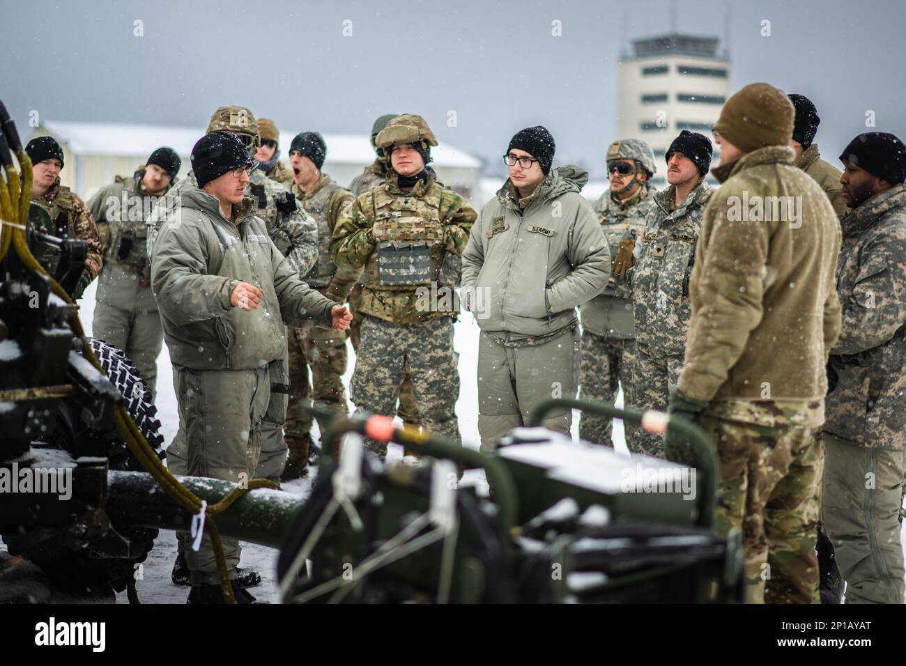 Army Sgt. Trevor Asmundsen, 1-120. Field Artillery Regiment, Wisconsin National Guard, weist ein Team von Soldaten beim Northern Strike 23-1, M119 24. Januar 2023, auf dem Grayling Army Airfield, Michigan, in die Schleuderladung ein. Einheiten, die an der Winterdurchführung von Northern Strike teilnehmen, bauen ihre Bereitschaft auf, indem sie gemeinsame Schulungen bei kaltem Wetter durchführen, um die Ziele der Arktis-Strategie des Verteidigungsministeriums zu erreichen. Stockfoto