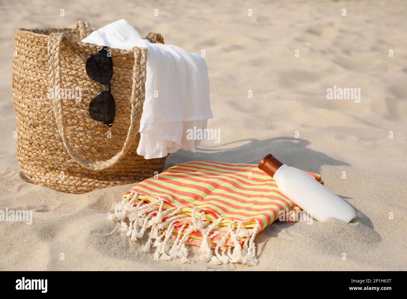 Strandtasche, Handtuch, Decke, Sonnenbrille und Sonnencreme auf Sand  Stockfotografie - Alamy