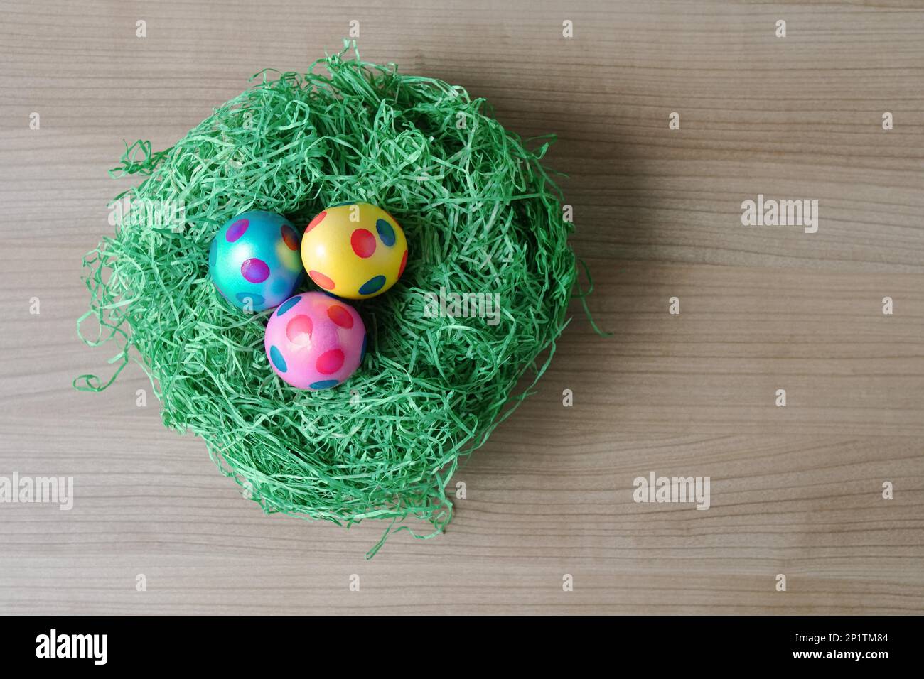 Blick von oben auf die drei gepunktet Ostern Eier in einem Nest aus Kunstgras Dekoration auf Tabelle mit Kopie Raum Stockfoto