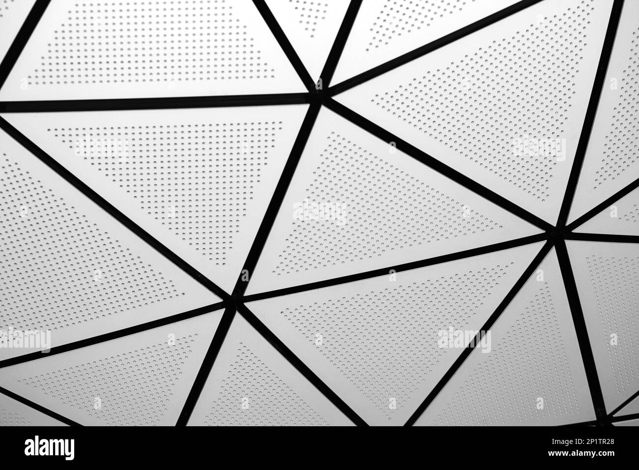 Abstraktes architektonisches Element. Nahaufnahme von dreieckigen Paneelen in einem modernen Gebäude. Stockfoto