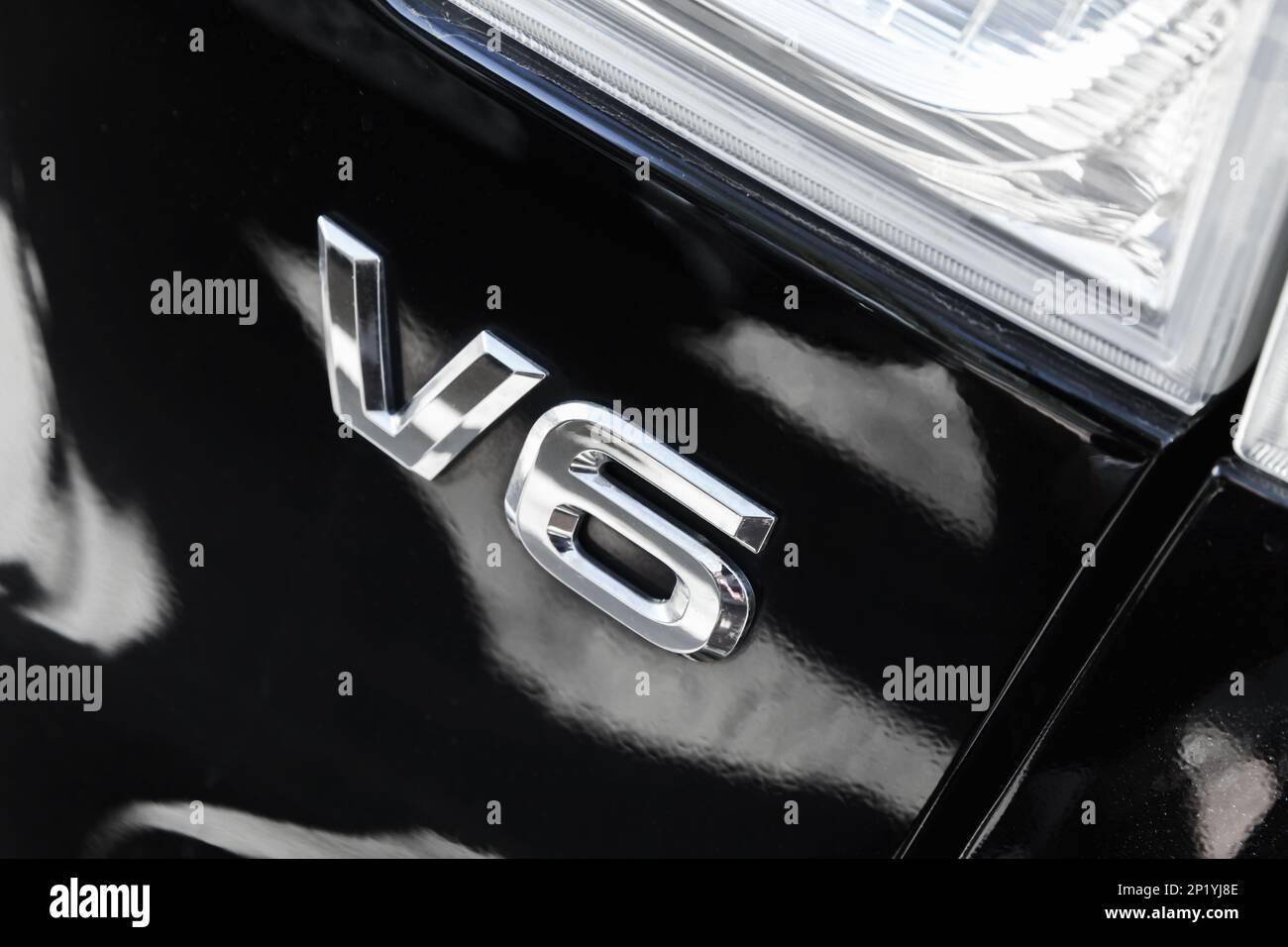 Glänzende Chrom-V6-Markierung auf schwarzer hinterer Motorhaube. Schild für Hochleistungs-Sechszylindermotor Stockfoto