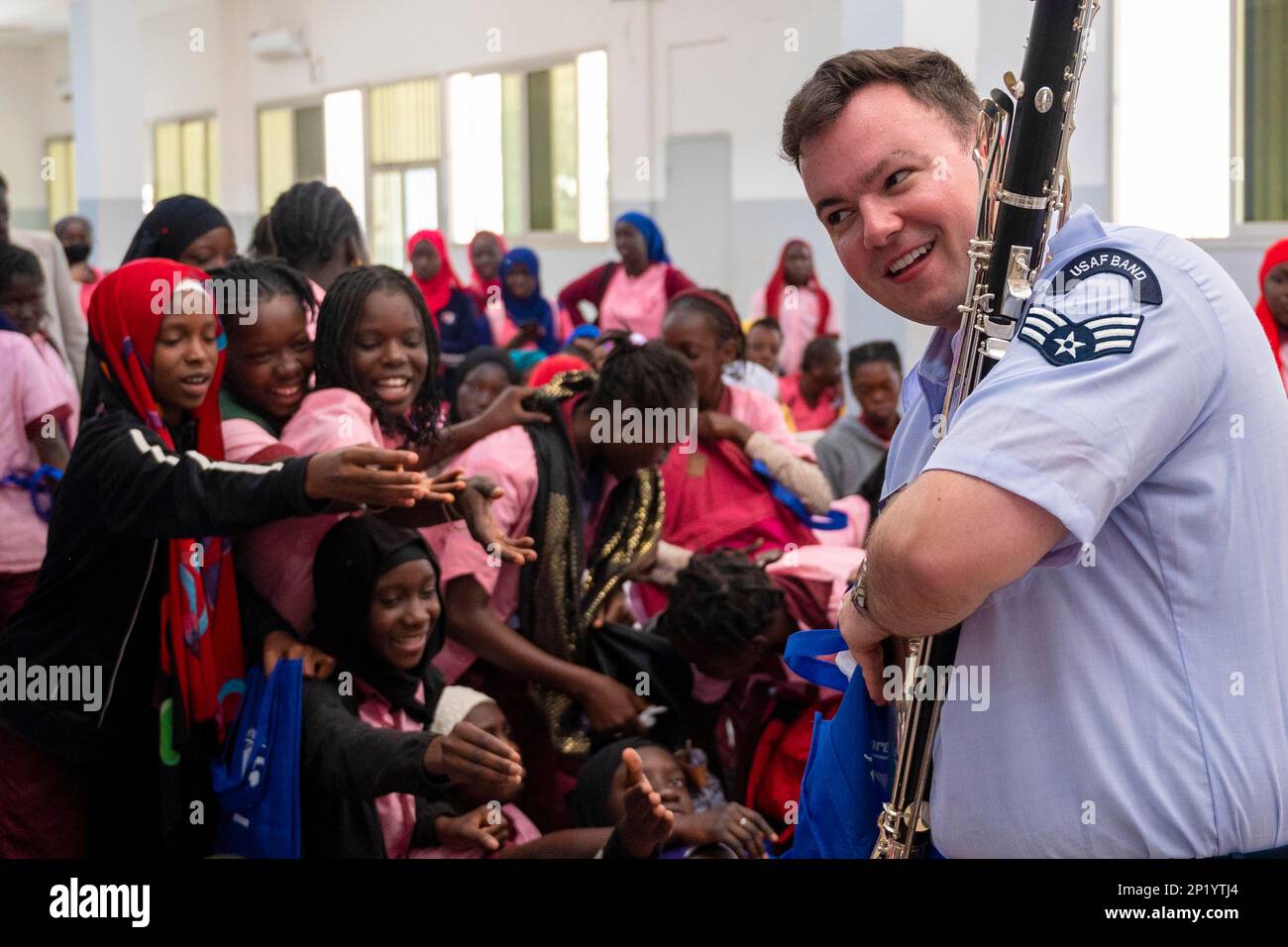 Dakar, Senegal. 1. März 2023. Studenten von John F. Kennedy De Dakar wenden sich an die USA Air Force Senior Airman James Campbell, USA Air Forces in Europe Air Forces Africa Band Clarinetist, der am 1. März 2023 in Dakar, Senegal, nach Geschenken greift. Im Rahmen eines umfassenden Ansatzes zur Bewältigung komplexer Sicherheitsherausforderungen in Afrika arbeiten wir eng mit afrikanischen, US-amerikanischen und internationalen Partnern zusammen, um Fähigkeiten zu entwickeln, die afrikanischen Partnern helfen können, regionale Sicherheitsherausforderungen zu bewältigen. Kredit: USA Air Force/ZUMA Press Wire Service/ZUMAPRESS.com/Alamy Live News Stockfoto