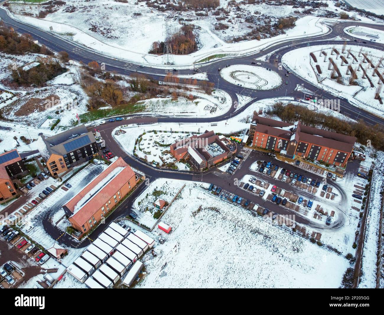 Luftdrohne. Ebbsfleet Garden City in Kent, im Dezember 2022 von Schnee bedeckt. Neubauten und gefrorener See entlang der Autobahn A2. Stockfoto