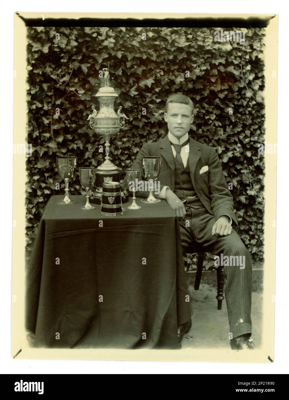 Original-viktorianisches Foto von Gent, auf einem Tisch ist eine große Worcester Challenge Vase,/Regatta-Trophäe zum Rudern und andere Tassen, möglicherweise Mitglied einer gefrästen vier Crew. Worcester und Umgebung, Großbritannien, ca. 1897-1899. Stockfoto