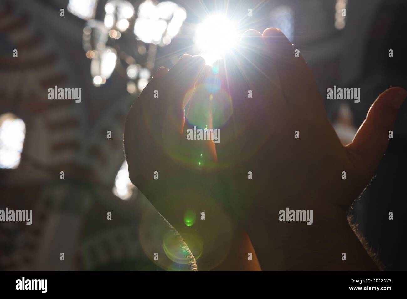 Islamisches Foto. Muslimischer Mann betet mit erhobenen Händen und direktem Sonnenlicht. Ramadan oder islamic oder Laylat al-qadr oder kadir gecesi Konzeptfoto. Selektiv Stockfoto