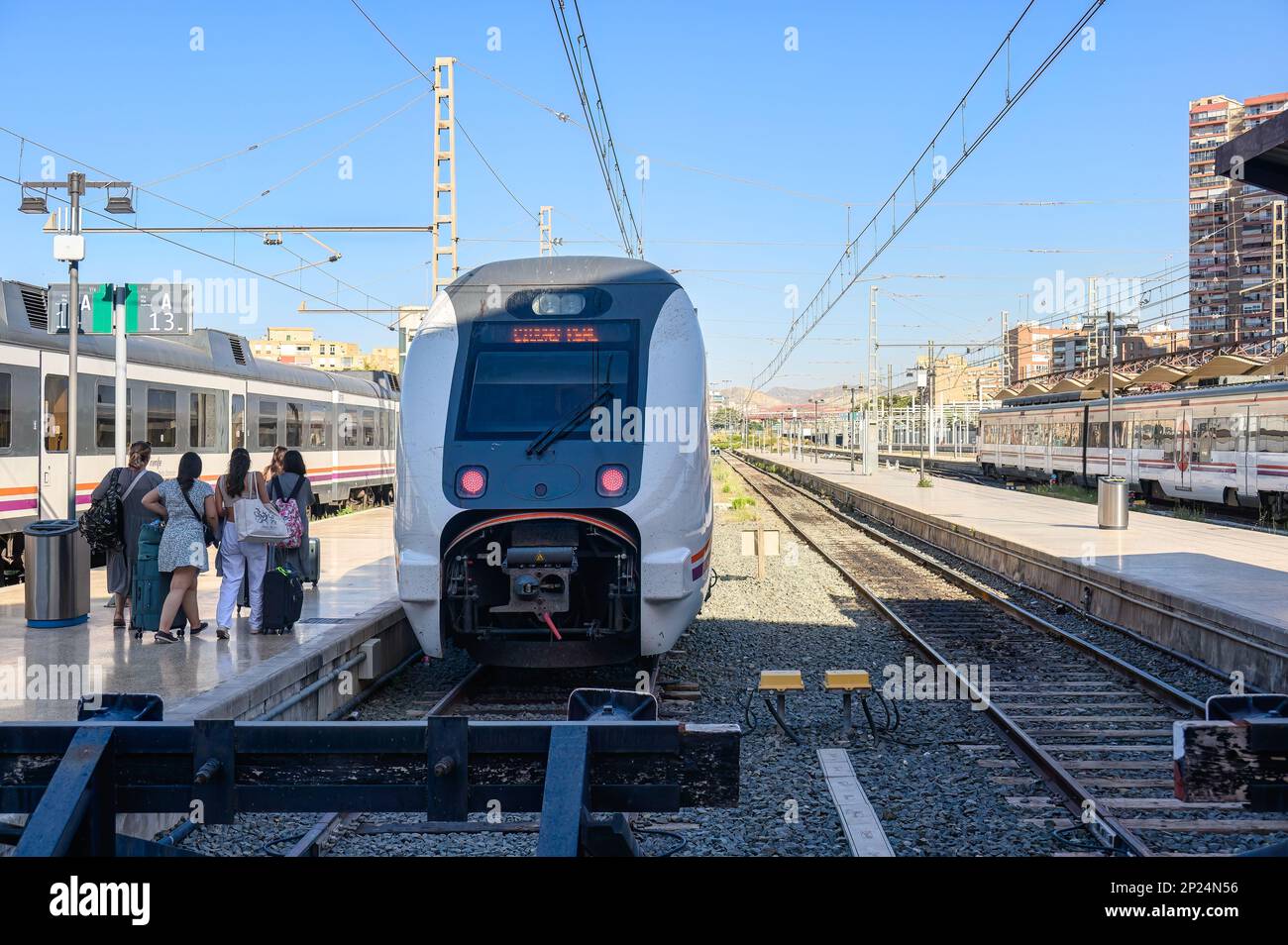 Alicante, Spanien - 14. Juli 2022: Menschen, die auf einen RENFE-Zug auf dem Bahnsteig zugehen Stockfoto