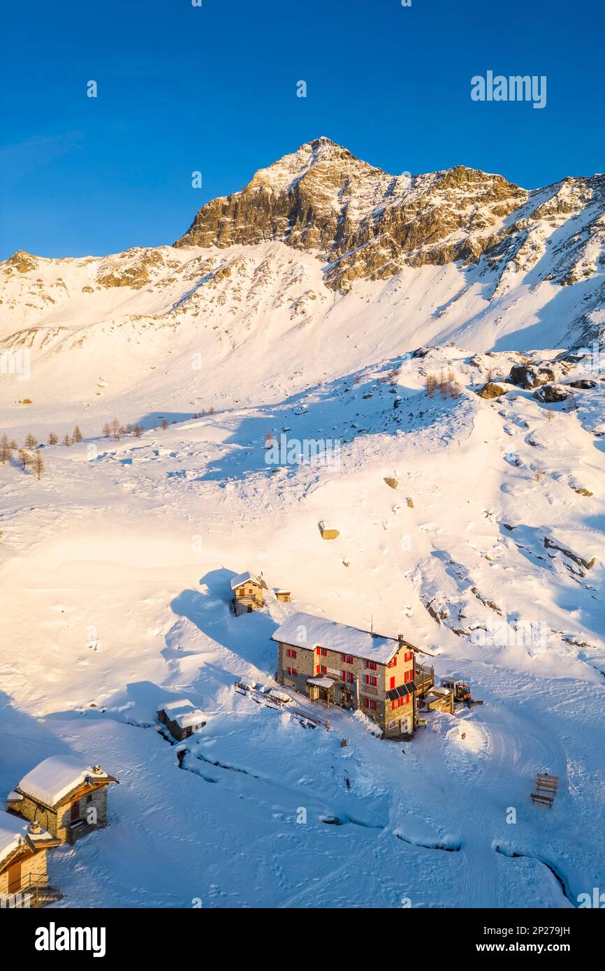 Sonnenuntergang vor Rifugio Cristina und Pizzo Scalino im Winter. Lanzada, Valmalenco, Valtellina, Sondrio District, Lombardei, Italien, Europa. Stockfoto