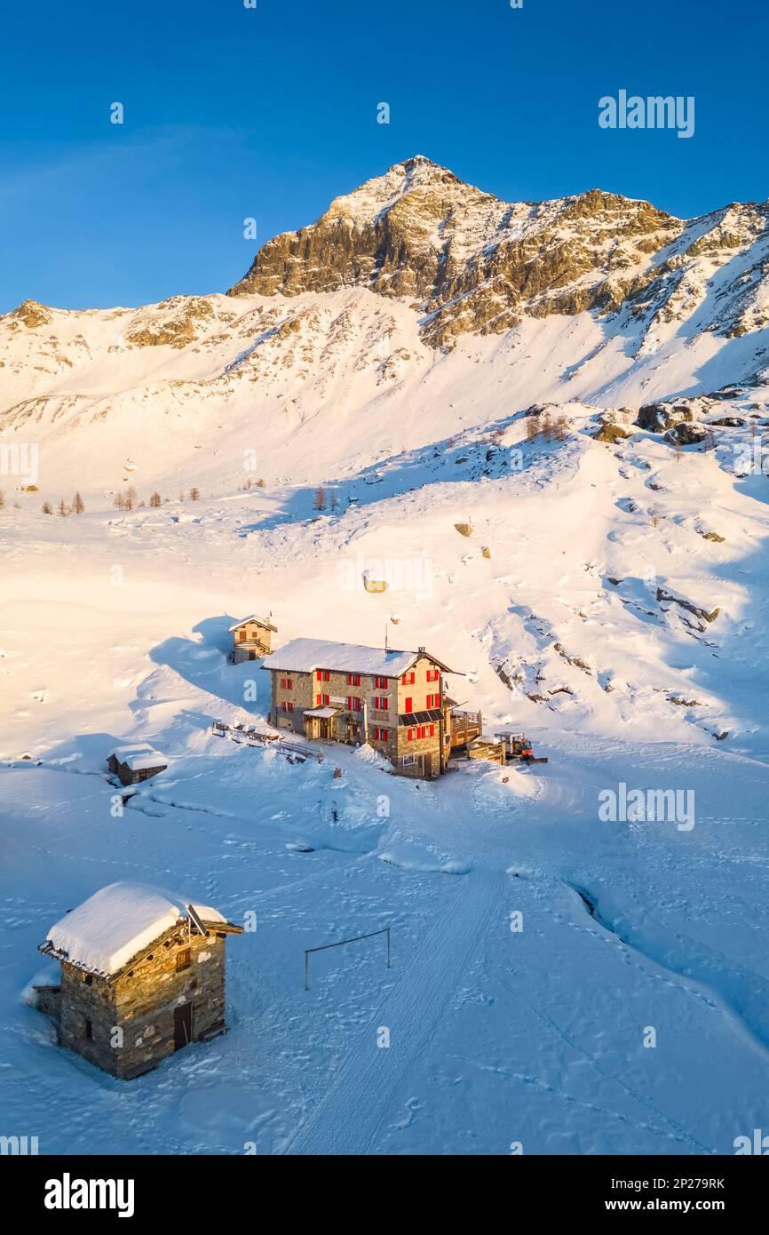 Sonnenuntergang vor Rifugio Cristina und Pizzo Scalino im Winter. Lanzada, Valmalenco, Valtellina, Sondrio District, Lombardei, Italien, Europa. Stockfoto