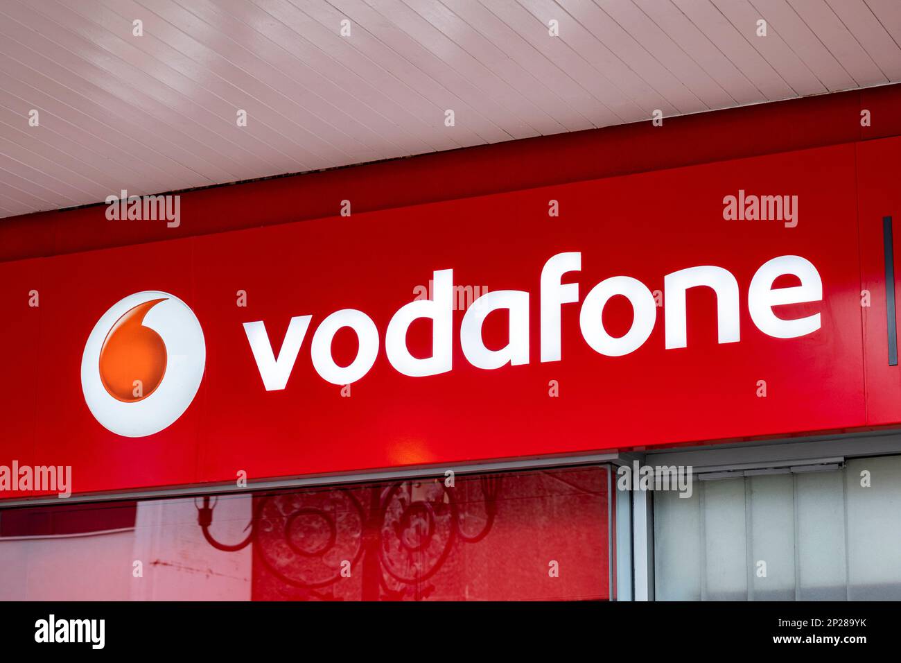 Nahaufnahme des Vodafone-Mobilfunknetzschilds an der Außenwand von Großbritannien Stockfoto