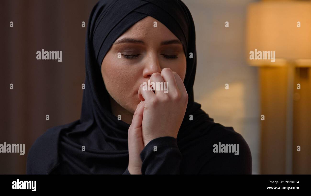 Traurig enttäuscht, verärgert, weinend arabische muslimische araberin Frau, multirassische Frau, Frau, sitzt in der Wohnung, ängstliche Freundin, weint allein, macht sich Sorgen Stockfoto