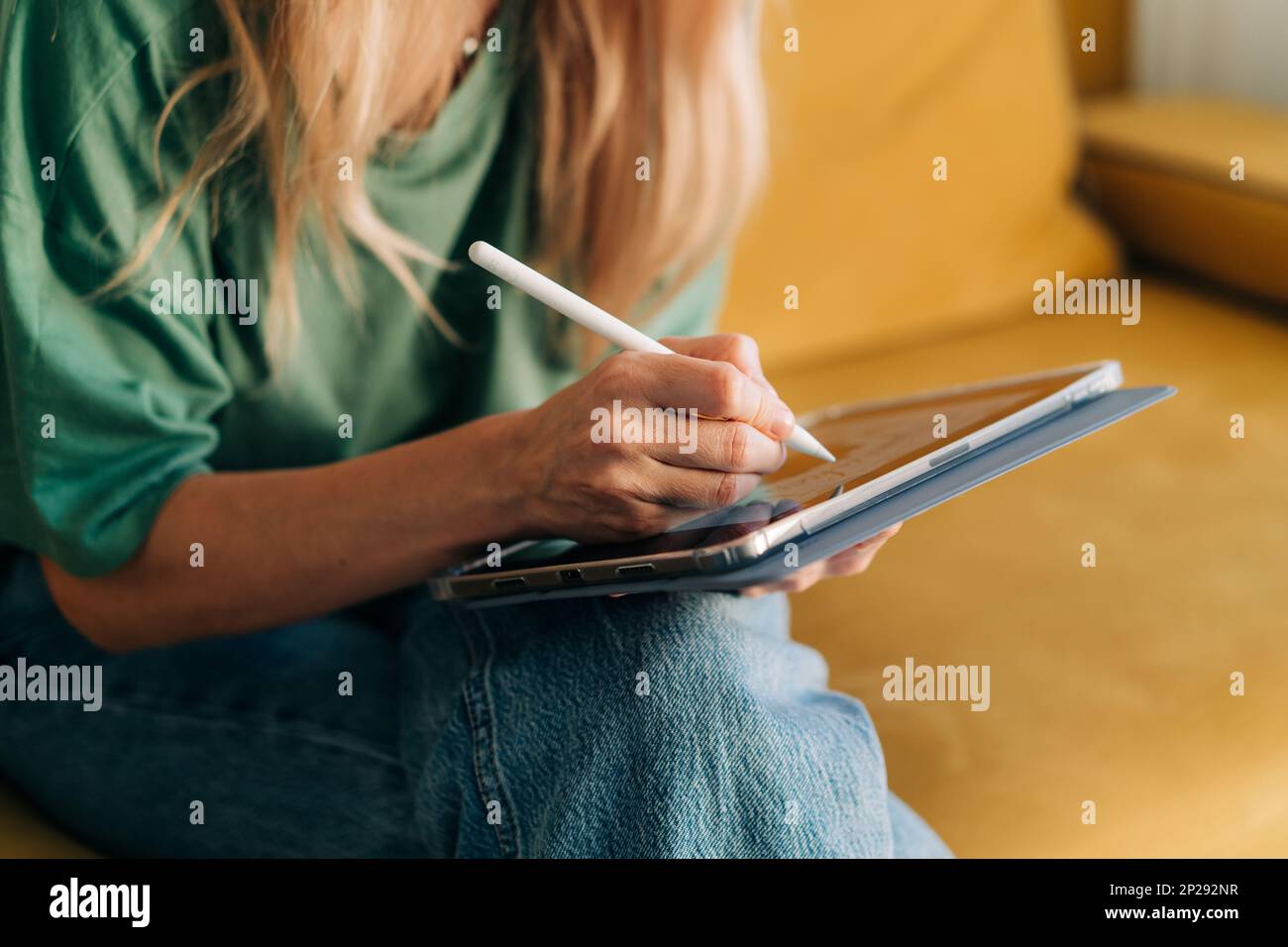 Nahaufnahme einer unbekannten Frau, die mit einem Eingabestift in einer App auf einem Tablet malt. Stockfoto