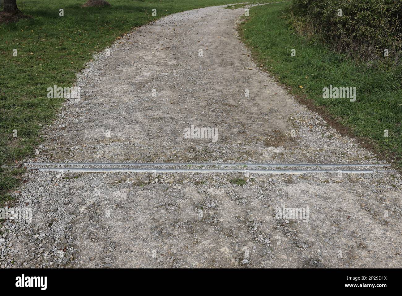Die Abflussrinne einer unbefestigten Straße ist mit Kies verstopft Stockfoto