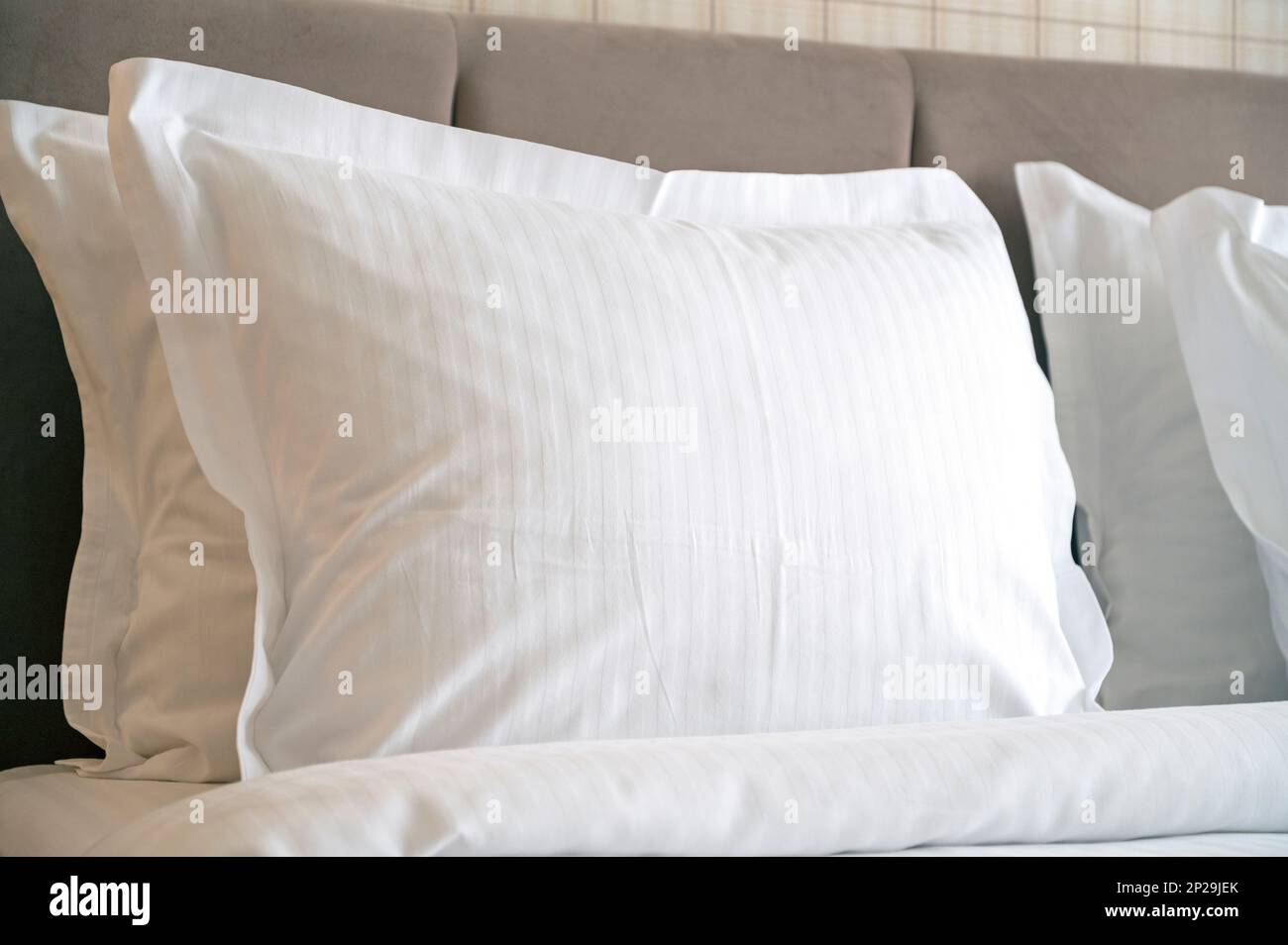 Nahaufnahme weißer Kissen auf einem Bett im Hotel, weißes sauberes Kissen in einem komfortablen Zimmer Stockfoto