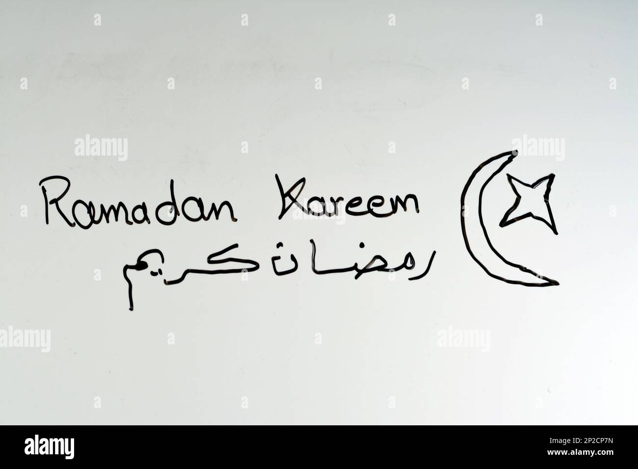 Ramadan Kareem Text in arabischer und englischer Handschrift auf einem Brett als festliche Dekoration für den Fastenmonat für Muslime festlich von Fanous Laterne I. Stockfoto