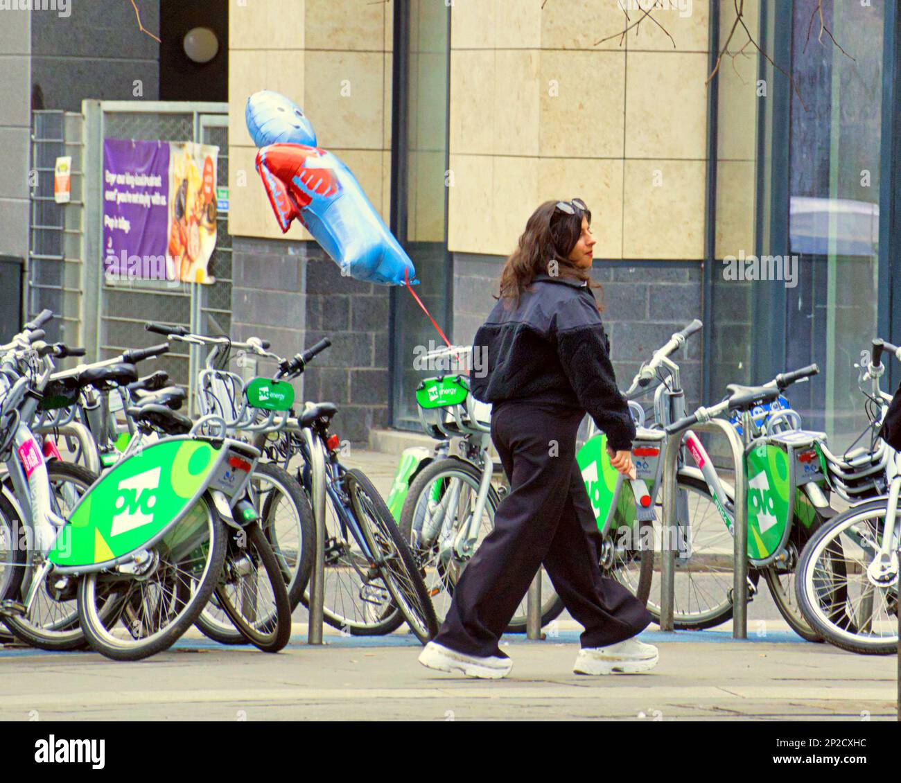 Glasgow, Schottland, Vereinigtes Königreich, 4. März 2023. UK Weather: Bei Sonnenschein im Frühling gingen die Einheimischen in Erwartung des Sommers auf die Straße. Ein Mädchen geht mit ihrem Ballon an den Leihfahrrädern am St. enoch Square vorbei. Credit Gerard Ferry/Alamy Live News Stockfoto