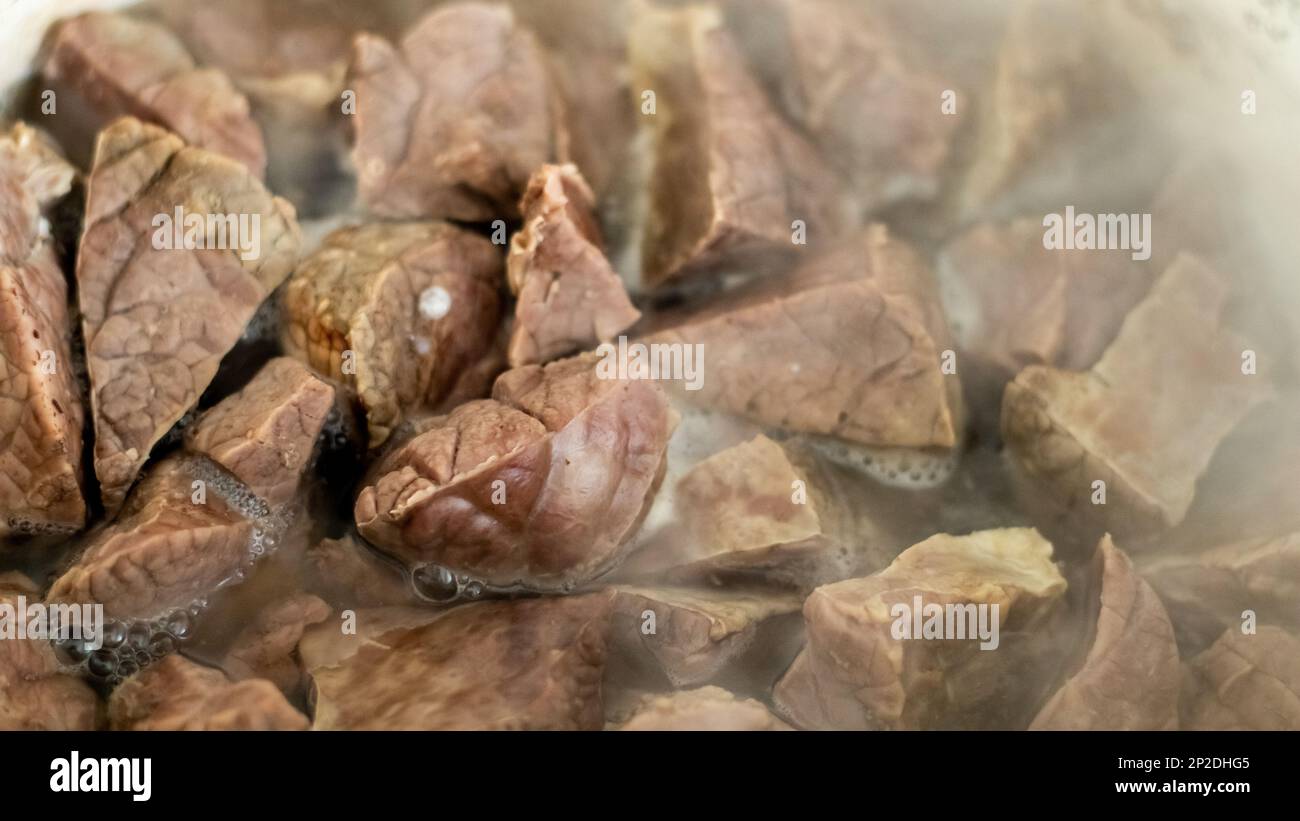 Schweinelunge in abgekochtem heißem Wasser. Nahaufnahme der Zubereitung eines thailändischen Gerichts. Gekochte Rind- oder Rinderlunge, Eingeweide aus Schweinefleisch. Stockfoto