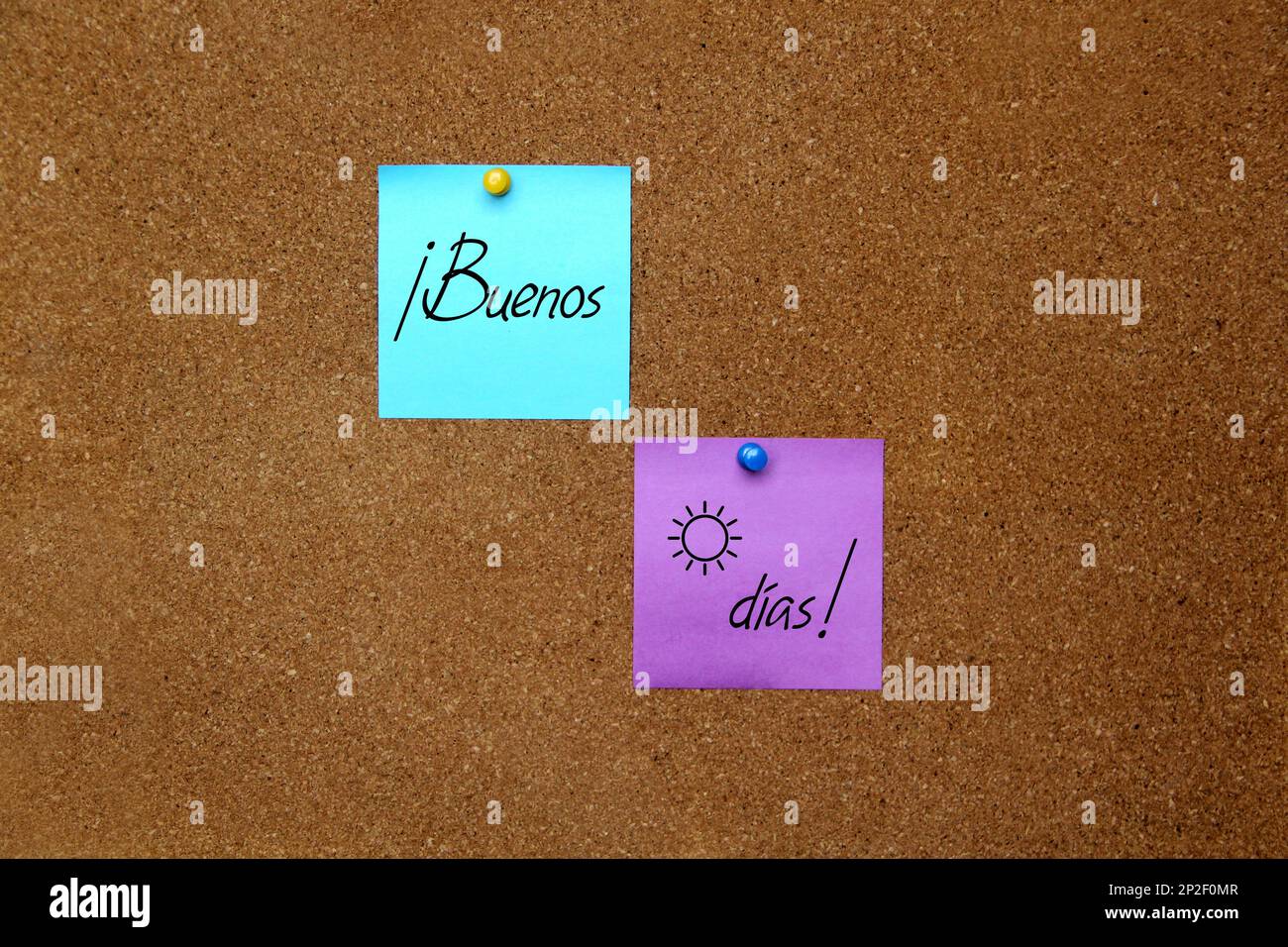 Mehrfarbige Notizen mit wichtigen Botschaften, Motivationen und Erinnerungen auf Korktafel und „Guten Morgen“ in spanischer Sprache Stockfoto