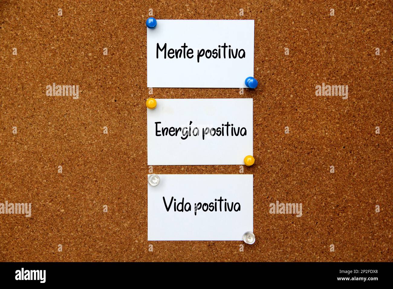 Weiße und mehrfarbige Hinweise auf Korktafel mit Botschaft in spanischer Sprache „positiver Geist, positive Energie, positives Leben“ Stockfoto