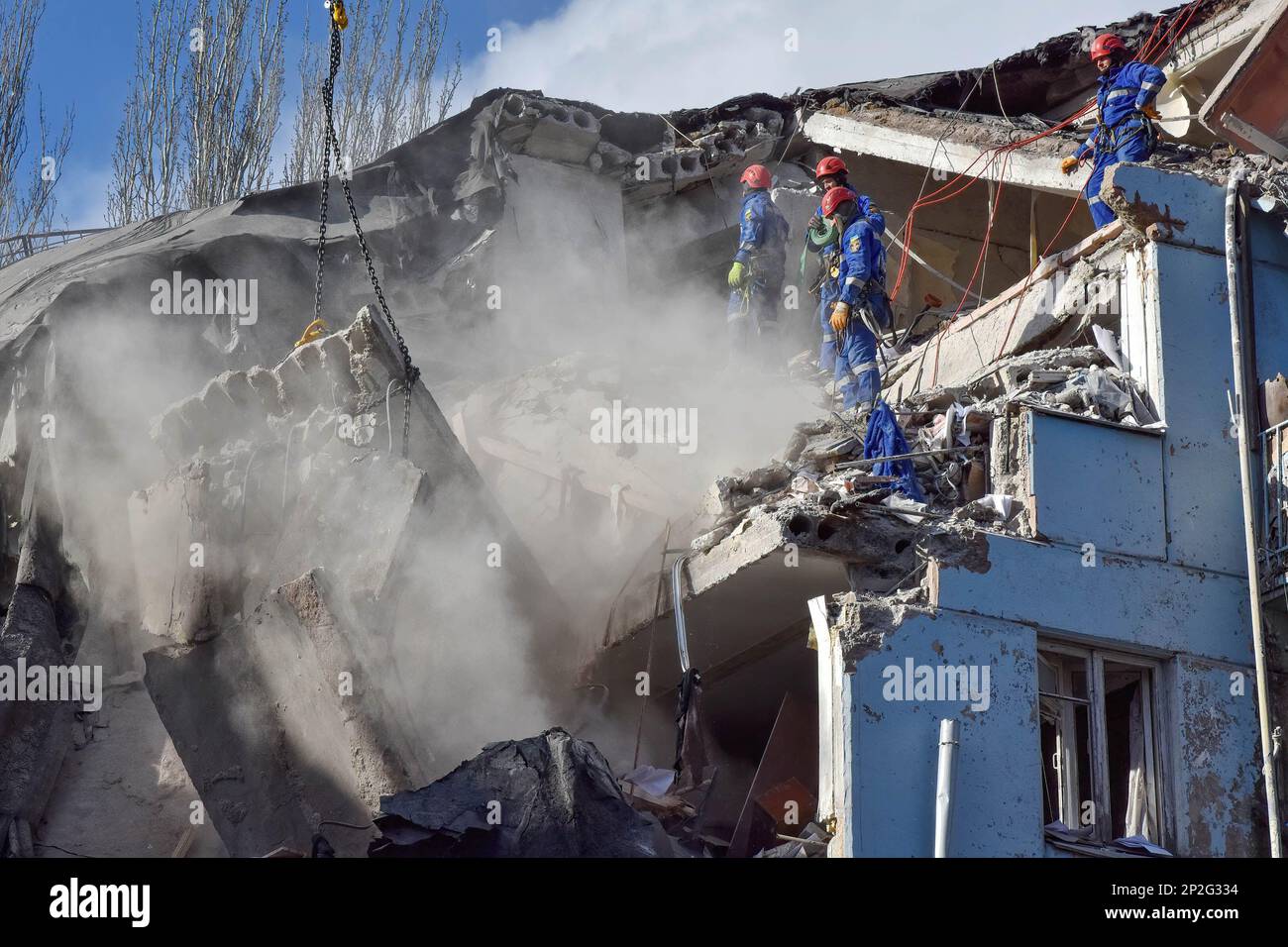 Mitarbeiter des ukrainischen staatlichen Rettungsdienstes inspizieren ein beschädigtes Haus, nachdem russischer Bombenanschlag in Zaporizhien getroffen wurde. Die Leichen von 10 Toten, darunter ein Kind, wurden aus den Trümmern eines Hauses geborgen, das von einer russischen Rakete getroffen wurde. Der staatliche Notdienst meldete dies am 4. März. 11 Menschen wurden gerettet. Zwei Katzen und ein Hund wurden während der Trümmerentfernung gerettet. Die Rettungsaktion ist im Gange. Stockfoto