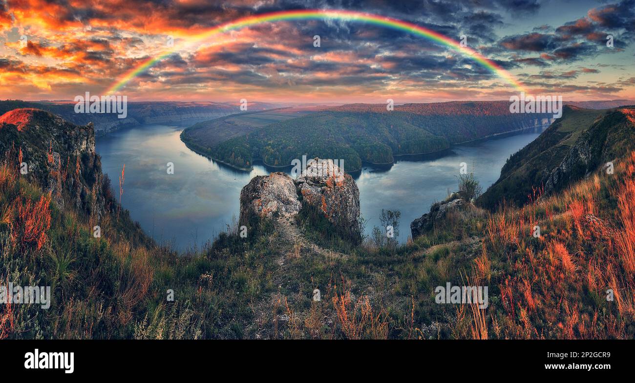 Farbenfroher Regenbogen über dem River Canyon. Herbstlandschaft. Art der Ukraine Stockfoto