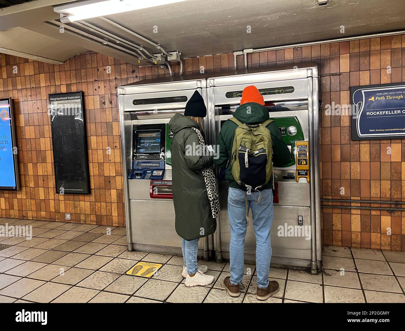Ein Paar an einem U-Bahn-Metrokartenautomaten an einem Bahnhof in Manhattan, New York City. Stockfoto