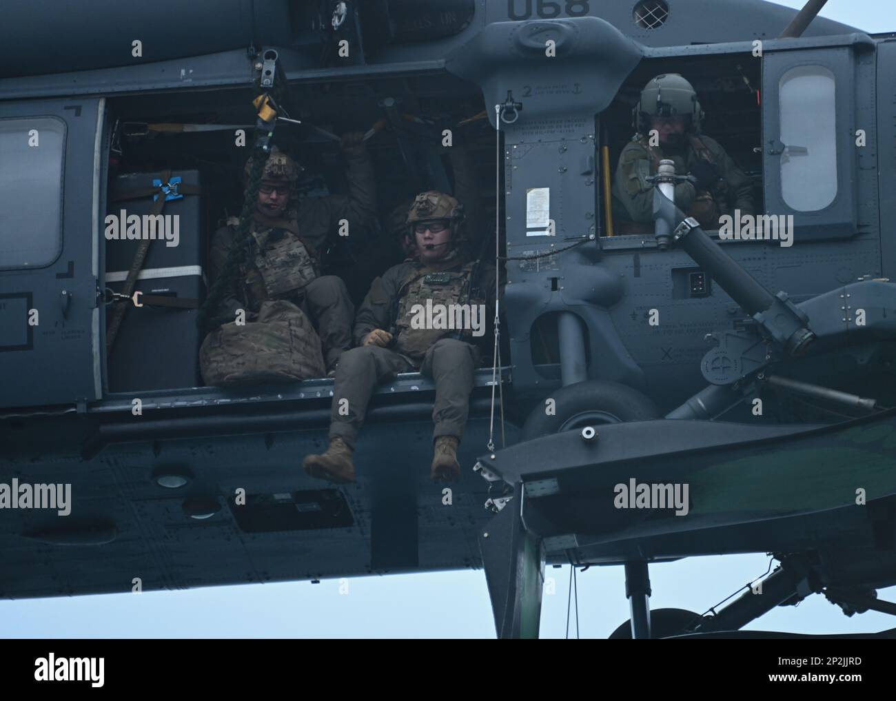 Mitglieder des Coast Guard Maritime Security Response Teams (MSRT) West bereiten sich vor, während einer gemeinsamen Service-Schulung am 11. Januar 2023 von einem 210. Rettungsgeschwader Alaska Air National Guard HH-60G Pave Hawk auf den Coast Guard Cutter Cypress in Kodiak, Alaska, zu springen. Die MSRT West-Mitglieder sind bereit, Einsatzkommandanten der Küstenwache und Kommandeure des Verteidigungsministeriums sowohl bei kurzfristigen Noteinsätzen als auch bei geplanten Sicherheitsereignissen zu unterstützen. - AUS DEN USA Foto der Küstenwache von Petty Officer 3. Klasse Ian Gray. Stockfoto