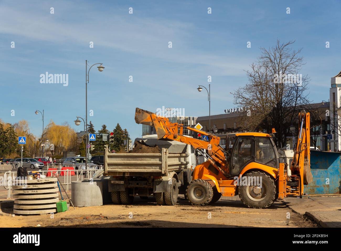 Grodno, Weißrussland - 06. März 2022: Arbeiter mit Hilfe von Erdbewegungsmaschinen bauen unterirdische Versorgungseinrichtungen in einer der ältesten Straßen wieder auf Stockfoto