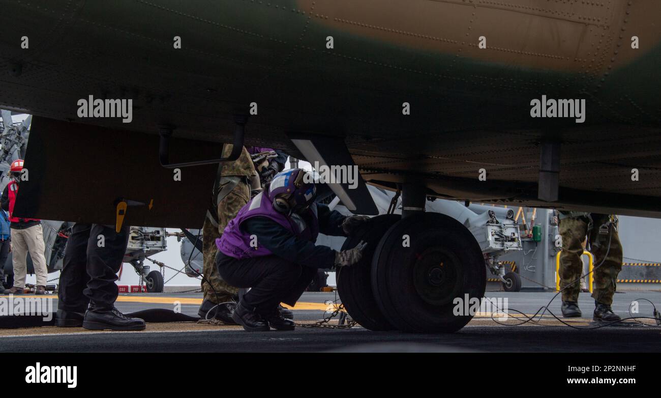 OSTCHINESISCHEN MEER (9. Februar 2023) Aviation Boatswain’s Mate (Fuel) Airman Kailey Barrientos, aus Carrollton, Georgien, dem nach vorn entsandten Amphibienflugzeugträger USS America (LHA 6) zugewiesen; Zum Anbringen eines Erdungskabels an einen Chinook-Hubschrauber der CH-47, der der Japan Ground Self-Defense Force (JGSDF) während des Flugbetriebs auf dem Cockpit des Schiffes im Rahmen der Übung Iron Fist während des Segelns im Ostchinesischen Meer zugeteilt ist, März 2. Iron Fist ist eine jährliche bilaterale Übung, die darauf abzielt, die Interoperabilität zu erhöhen und die Beziehungen zwischen den USA zu stärken Marine Corps, die USA Navy, das J Stockfoto