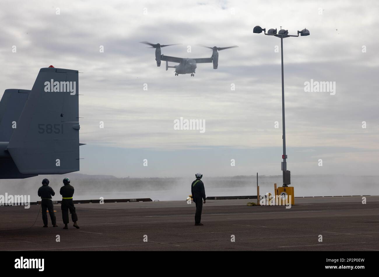 USA Marines mit Marine Medium Tiltrotor Squadron (VMM) 163, Marine Aircraft Group 16, 3. Marine Aircraft Wing, beobachten Sie, wie ein MV-22B Osprey sich auf die Landung am National City Pier in San Diego am 24. Februar 2023 vorbereitet. Das Geschwader stellte die Ospreys für den Seetransport bereit, um einsatzorganisierte Kampfelemente und Unterstützung für die Luftfahrt bereitzustellen. (USA Marinekorps (Foto): Lance CPL. Courtney A. Robertson) Stockfoto