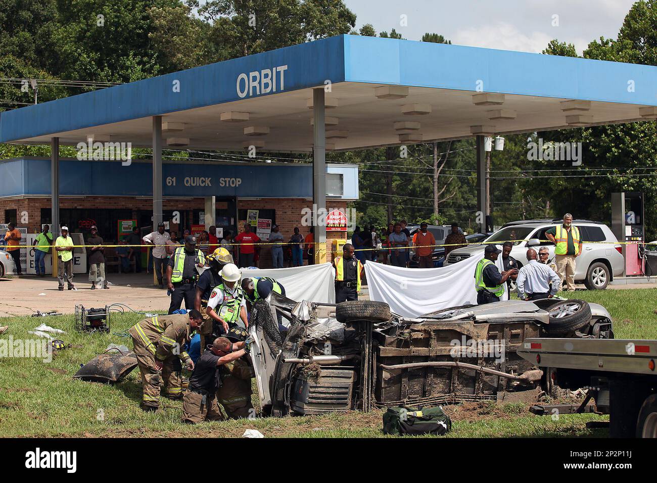 Vicksburg firefighters work to remove a woman trapped inside her car at