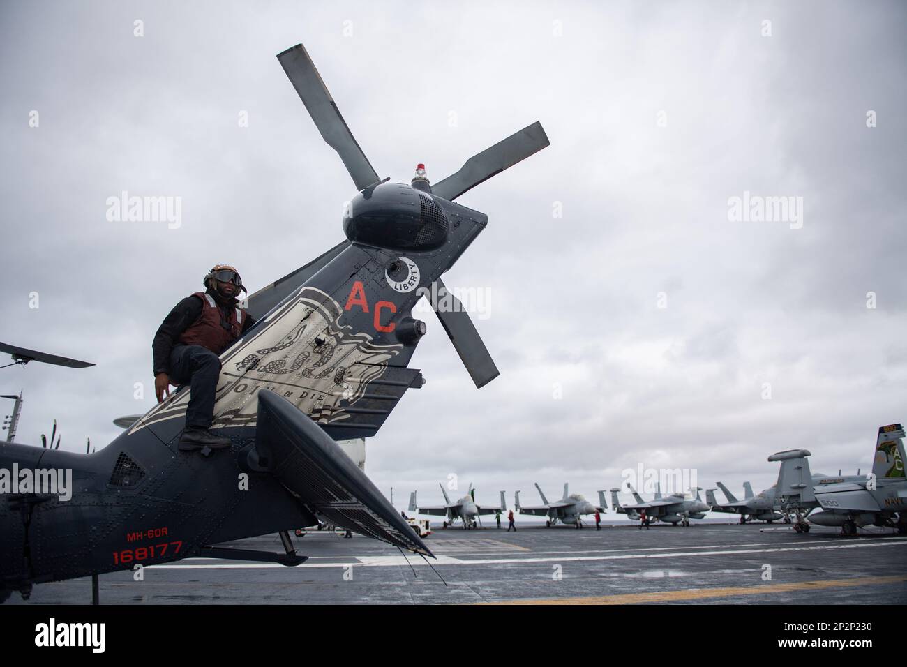 230226-N-GJ011-1019 ATLANTIC OCEAN (26. Februar 2023) Aviation Structural Mechanic Airman Jaron Miller aus Little Rock, Arkansas, führt Wartungsarbeiten am Heck eines MH-60R Sea Hawk Hubschraubers durch, der an den „Sumpffüchsen“ des Helicopter Maritime Strike Squadron (HSM) 74 befestigt ist, an Bord des Flugzeugträgers USS Dwight D. 69 der Nimitz-Klasse. IKE führt mit dem in den Boarked Carrier Air Wing 3 eingeleiteten Tailored Ship's Training Availability (TSTA) und Final Evaluation Problem (FEP) als Teil der Grundphase des Optimized Fleet Response Plan durch. (USA Navy-Foto von Mass Communication Stockfoto