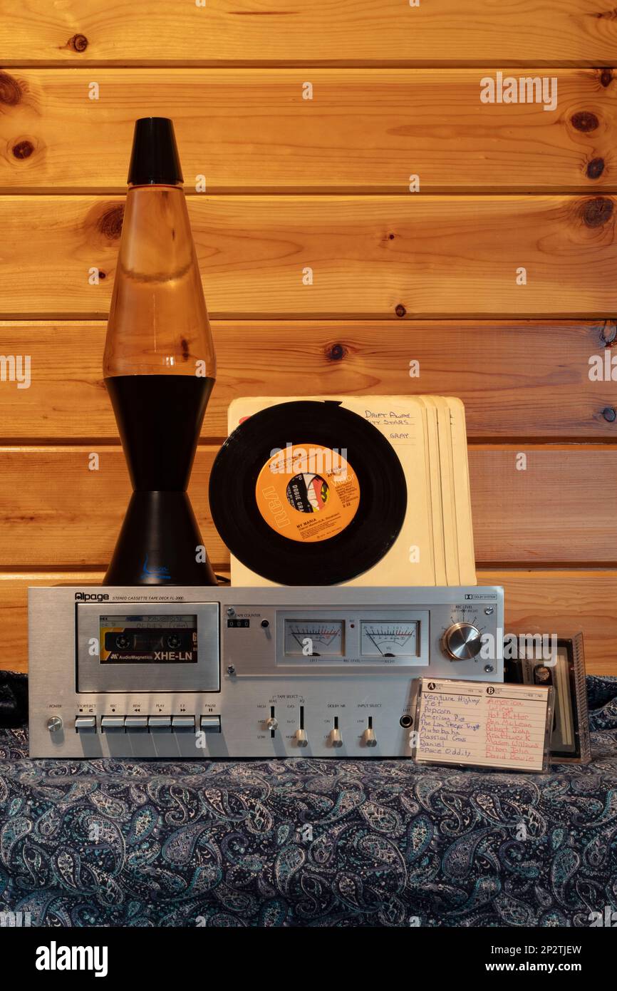 Eine groovy Nostalgie aus den 1970er Jahren: Eine (nicht funktionierende) Lava-Lampe, 45s, Kassetten mit den Oldies und ein klassisches Kassettendeck. Stockfoto