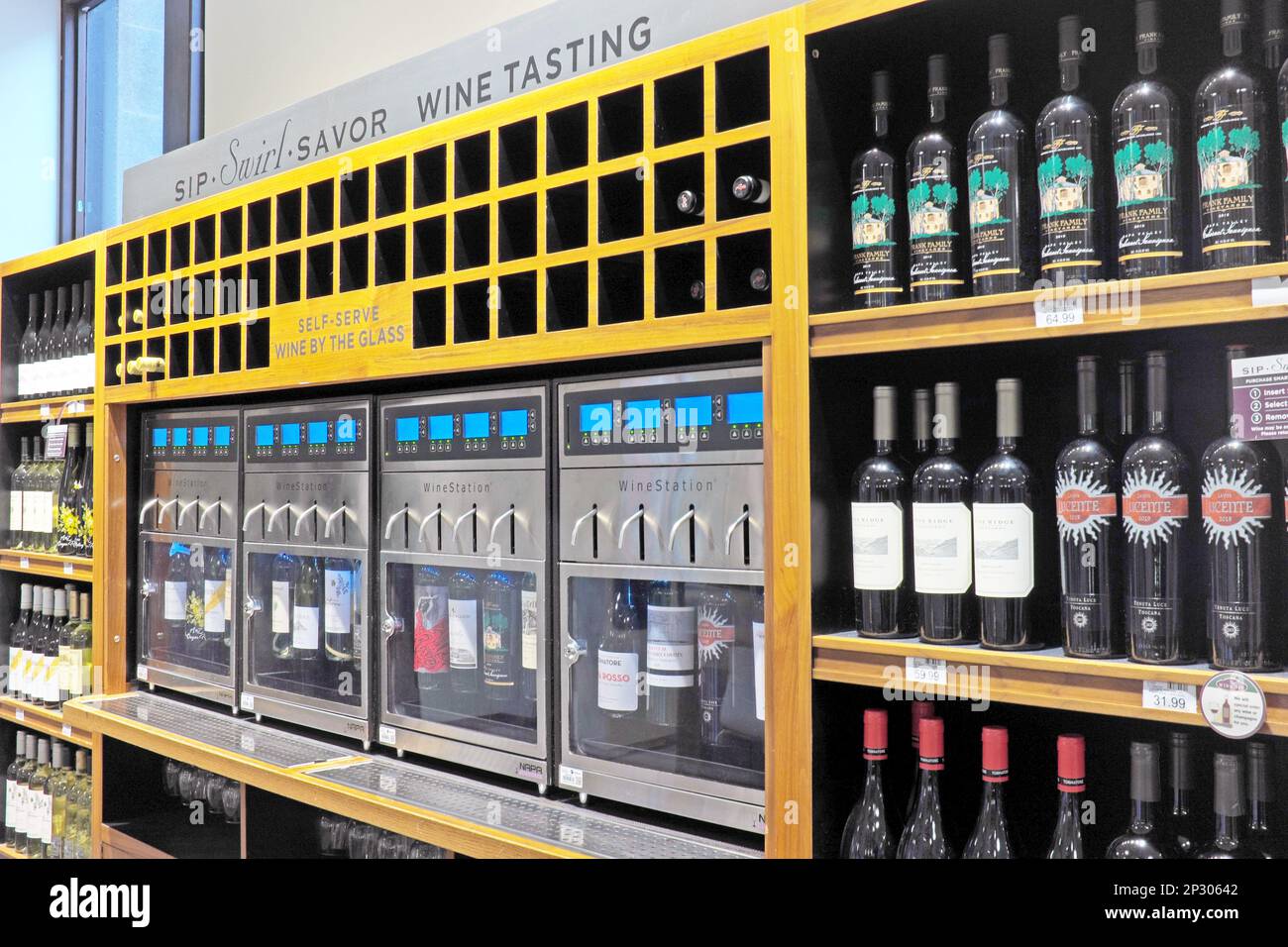 Vier gekühlte Wine-by-the-Glass-Automaten mit 16 Weinen, die Sie in einem gehobenen Lebensmittelgeschäft in Cleveland, Ohio, USA, probieren oder kaufen können. Stockfoto
