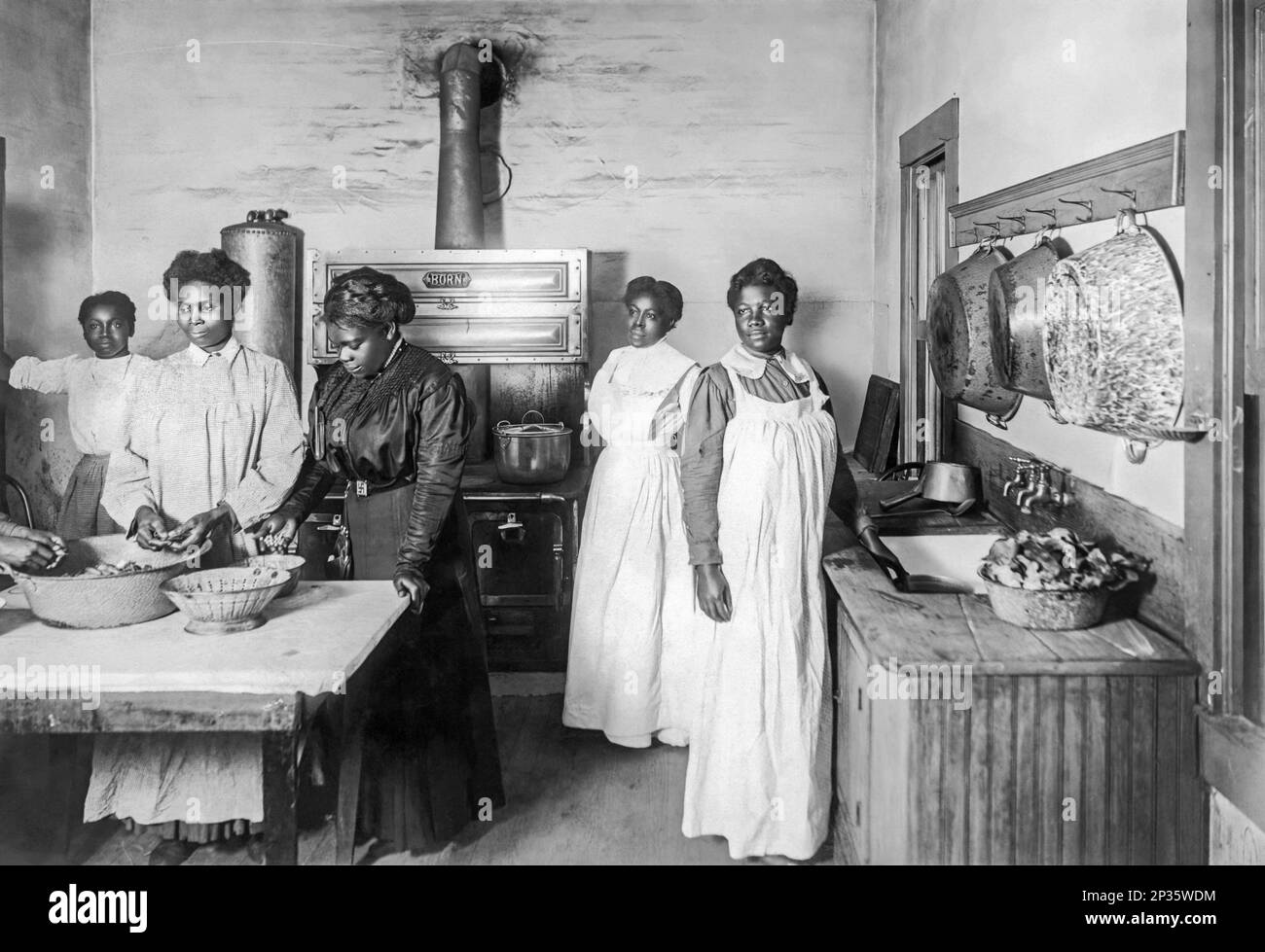 Mary McLeod Bethune (dritte von links) bei der Zubereitung der Mahlzeit mit Schülern des Daytona Normal and Industrial Institute for Girls etwa 1912 in Daytona Beach, Florida. Stockfoto