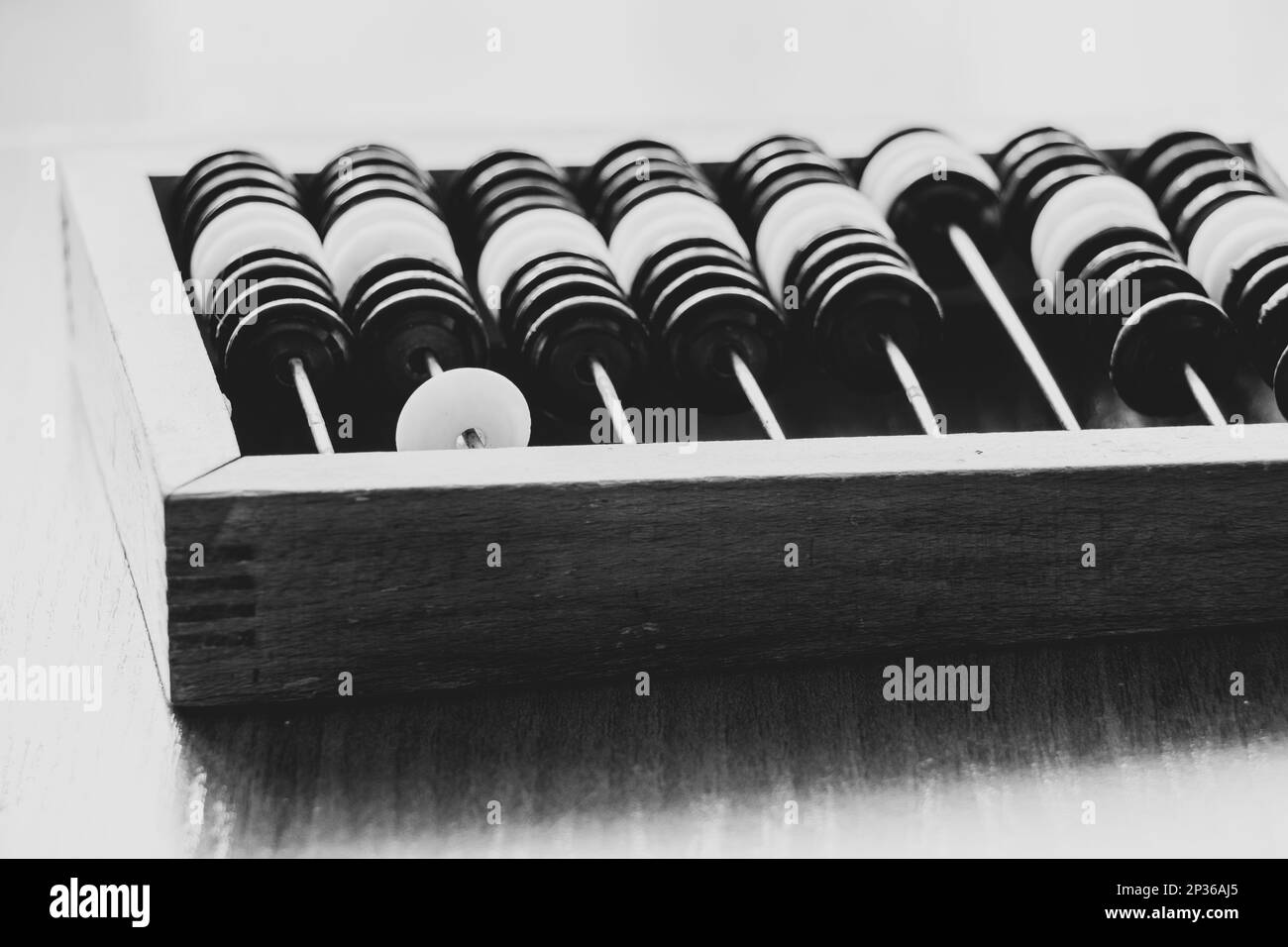 Alter Holzabakus, um Geld auf einem Holztisch zu zählen, Nahaufnahme Schwarz-Weiß-Foto Stockfoto