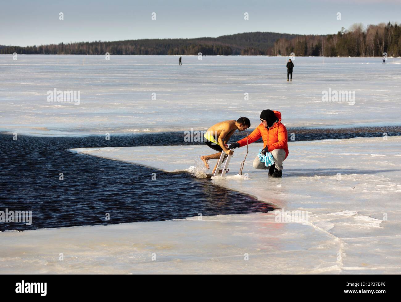 Das jährliche Winterfestival in Ludvika Schweden lockt die Menschen an, ein Bad bei 2 Grad Celsius zu nehmen, aber die Sonne scheint. Stockfoto