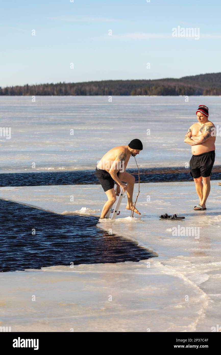 Das jährliche Winterfestival in Ludvika Schweden lockt die Menschen an, ein Bad bei 2 Grad Celsius zu nehmen, aber die Sonne scheint. Stockfoto