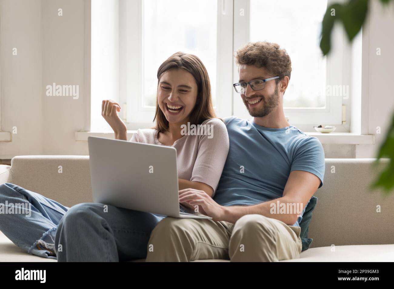 Ein fröhliches Paar, das sich auf einem Laptop per Videogespräch verliebte Stockfoto